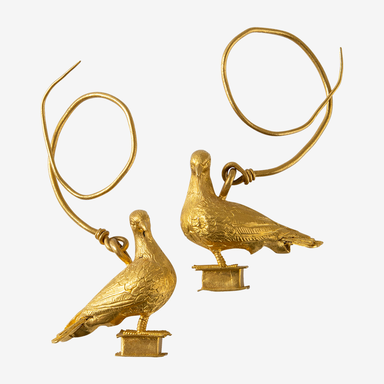 Ζεύγος χρυσών ενωτίων (σκουλαρικιών) με παράσταση περιστεριών. Τα περιστέρια είναι αγαπητό σχέδιο στην κοσμηματοτεχνία, ήδη από τον 3ο αι. π.Χ., όπως και οι ερωτιδείς, οι σειρήνες και άλλες φτερωτές μορφές.